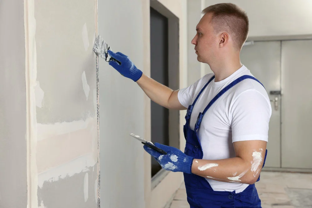 Hombre estucando pared